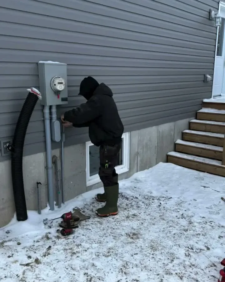 Electrician at the meter base and service conduit for a Generac standby generator install in Dundalk