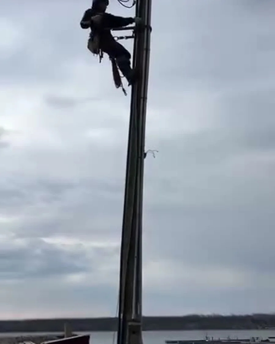 Dunne Power lineman climbing the old hydro pole on spurs at Wiarton Marina, before the new Class 3 pole goes in
