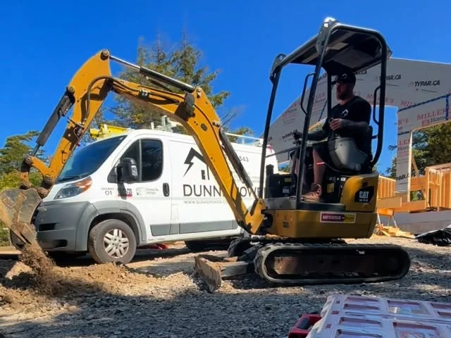 Dunne Power excavator trenching an underground service, van in the background