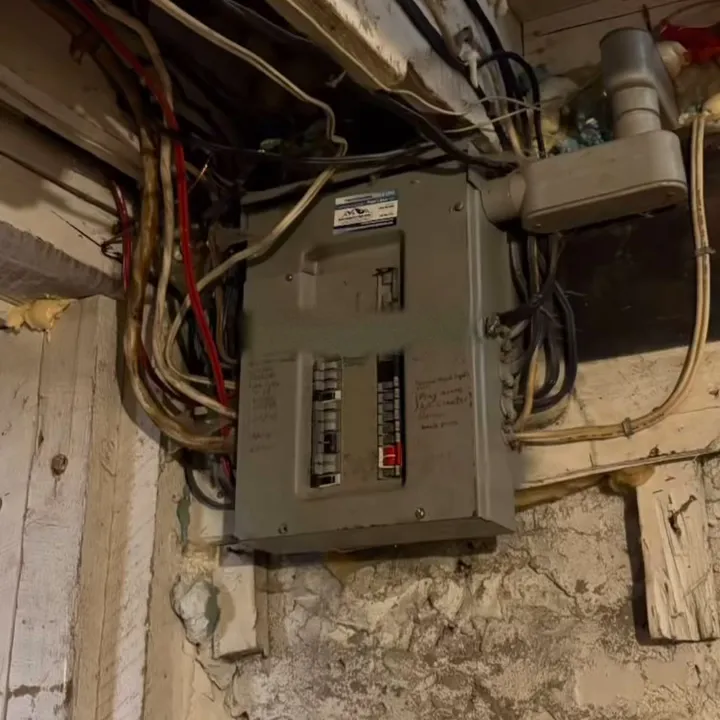 The old panel and tangled wiring in the Chesley basement before the upgrade